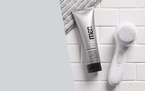Mary Kay Skinvigorate Sonic Skin Care System shown on white subway bathroom tile with grey towel and MKMen Daily Face Wash