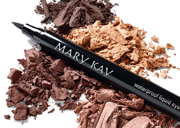 Mary Kay Eyeliner on top of three eye shadow rubs in different shades from light to dark neutrals on a white background.