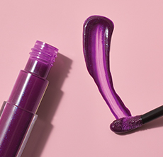 Close-up of one applicator tip and a deep purple swipe of new Mary Kay Unlimited Lip Gloss