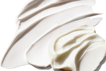 Creamy product rubs smeared over a solid background