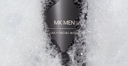 MKMen Daily Facial Wash surrounded by foamy cleanser bubbles
