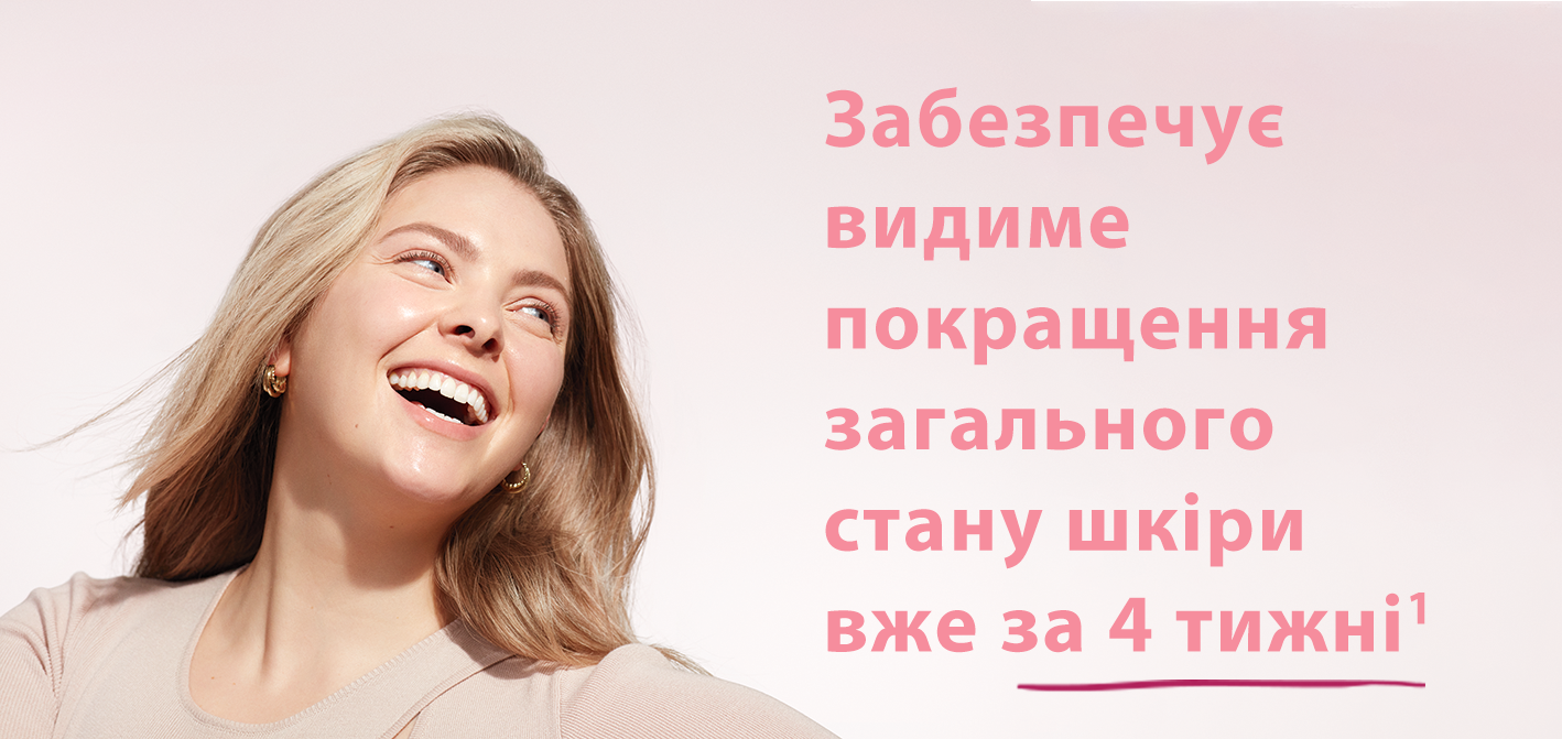 Two black women posing closely together while smiling at the camera surrounded by sunlit lighting and a light pink background