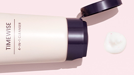 An open TimeWise 4-In-1 Cleanser next to a dime-sized dollop of product on a light pink background